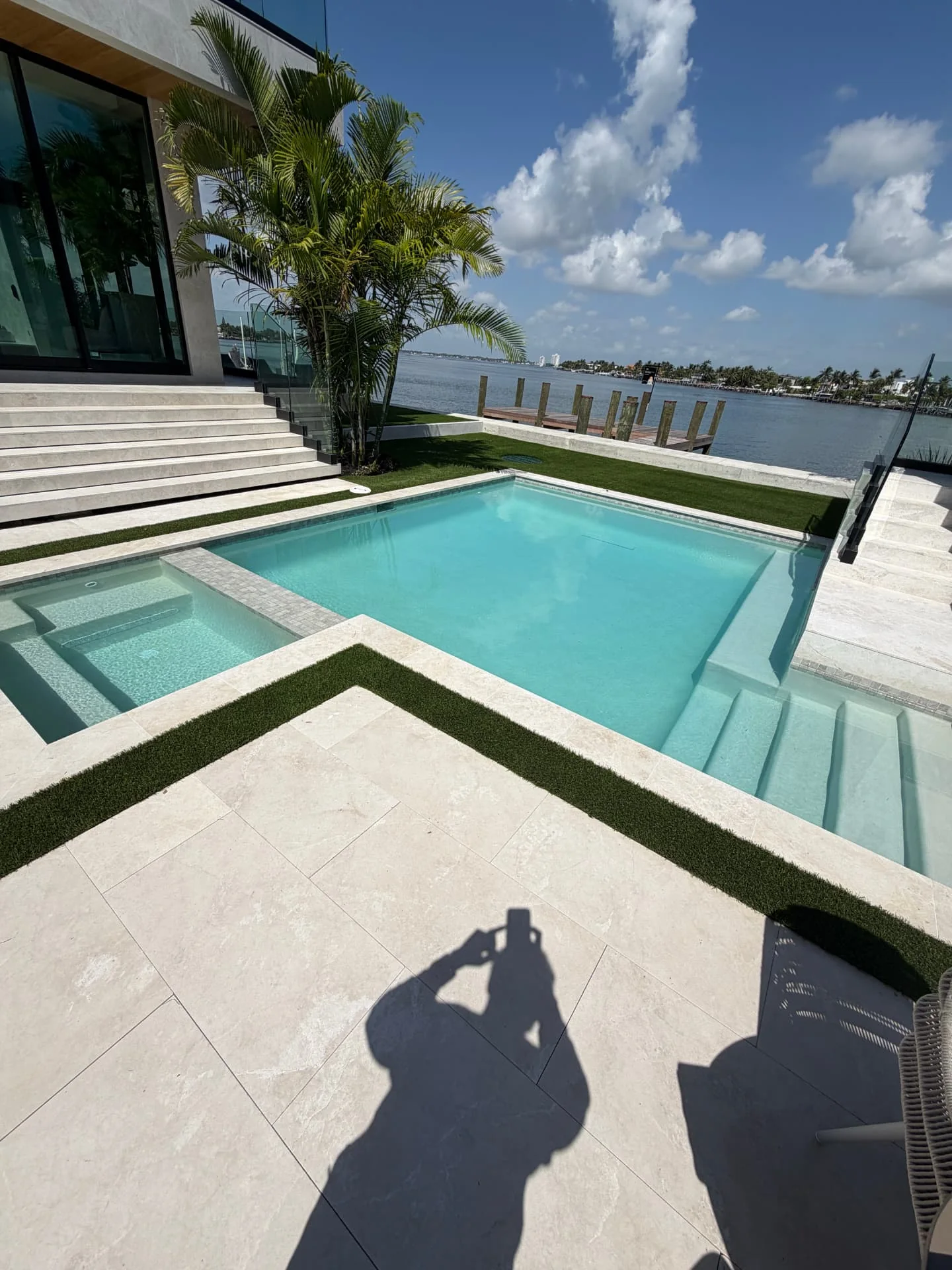 Modern pool beside a dock and bay in South Florida