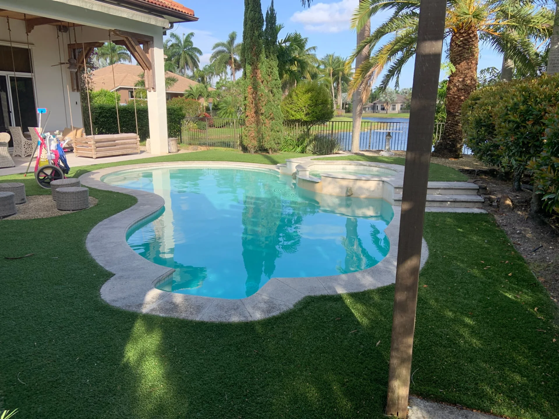 Kidney-shaped pool with a lake view maintained by Pool Vice